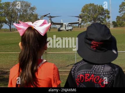 I bambini australiani osservano gli Stati Uniti Marine Corps MV-22 Osprey from the Aviation Combat Element, Marine Rotational Force-Darwin (MRF-D) 22, atterra alla Royal Darwin Show Fairgrounds, Darwin, NT, Australia, durante una fiera di carriera della Australian Defence Force (ADF), 6 agosto 2022. Marines con MRF-D 22 ha partecipato alla fiera di carriera ospitata dall'ADF che ha avuto una serie di esposizioni, bancarelle di carriera, attività interattive e dimostrazioni. Foto Stock