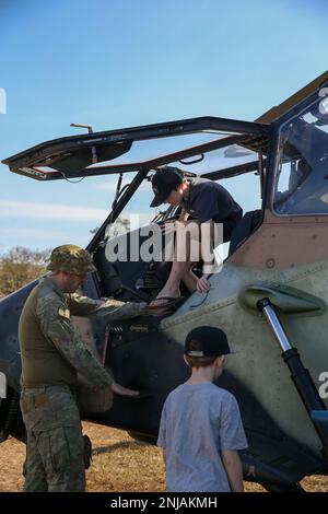 Un soldato dell'esercito australiano mostra ai bambini come uscire correttamente da una tigre Eurocopter EC665 durante una fiera della carriera della forza di difesa australiana (ADF) al Royal Darwin Show Fairgrounds, Darwin, NT, Australia, 6 agosto, 2022. Marines con MRF-D 22 ha partecipato ad una fiera di carriera ospitata da ADF che ha avuto una serie di esposizioni, bancarelle di carriera, attività interattive e dimostrazioni. Foto Stock