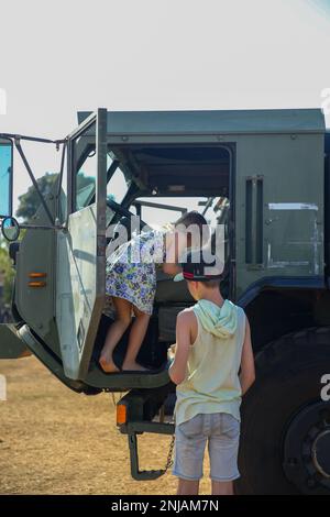 I bambini australiani visitano gli Stati Uniti Marine Corps Logistic Vehicle System Replacement from the Logistics Combat Element, Marine Rotational Force-Darwin (MRF-D) 22, durante una fiera di carriera della forza di difesa australiana (ADF) alla Royal Darwin Show Fairgrounds, Darwin, NT, Australia, 6 agosto, 2022. Marines con MRF-D 22 ha partecipato all'esposizione professionale ospitata dall'ADF che ha avuto una serie di esposizioni, bancarelle, attività interattive e dimostrazioni. Foto Stock