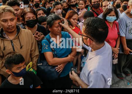 Città di Antipolo, Rizal, Filippine. 22nd Feb, 2023. Adoratore riceve segni di croce di cenere sulla fronte durante l'osservanza del Mercoledì delle Ceneri nella città di Antipolo. Il mercoledì delle Ceneri è tradizionalmente osservato dai cattolici, che ricevono i segni della fronte con cenere e digiuno per iniziare il tempo quaresimale. La croce di cenere sulla fronte degli osservatori è destinata a simboleggiare la mortalità e la penitenza per il loro peccato. (Credit Image: © Ryan Eduard Benaid/ZUMA Press Wire) SOLO PER USO EDITORIALE! Non per USO commerciale! Foto Stock