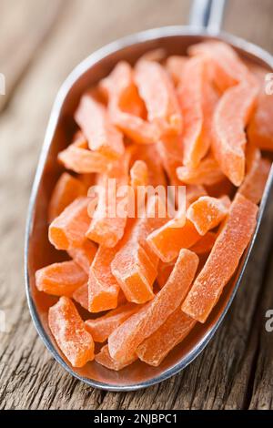 Bastoncini di papaya canditi o glacé in metallo su legno (fuoco selettivo, fuoco sull'estremità anteriore dei bastoncini di papaya) Foto Stock