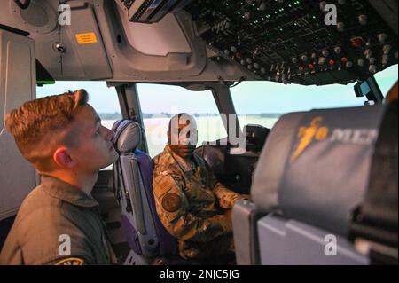 STATI UNITI Air Force Senior Airman carter Simons, a sinistra, un padrone di strada con il 155th Airlift Squadron, 164th Airlift Wing, Tennessee National Guard, mostra Capo Master Sgt. Maurice L. Williams, capo comando, Air National Guard, intorno al simulatore pilota nell'edificio delle operazioni presso la base della Guardia Nazionale aerea di Memphis a Memphis, Tennessee 6 agosto 2022. Mentre era nel simulatore, Simons descriveva a Williams le differenze tra il simulatore pilota e il simulatore loadmaster. Foto Stock