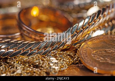 Gioielli d'oro, monete d'oro e barre d'oro in un primo piano Foto Stock