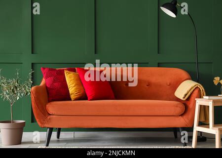 Divano rosso con eleganti cuscini nel soggiorno Foto Stock