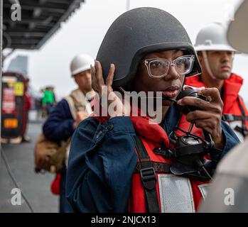 220806-N-YC581-1091 OCEANO PACIFICO (6 agosto 2022) – Seaman Treasure Johnson trasmette un messaggio al ponte durante un rifornimento in mare dal ponte di volo della nave d'assalto anfibio USS Makin Island (LHD 8), 6 agosto. Gli addetti al telefono sono responsabili dell'inoltro di tutte le informazioni pertinenti dai gestori di linea al bridge e di tutti gli ordini dal bridge ai gestori di linea. Makin Island, ammiraglia di Anfibio Squadrone (CPR) SETTE, insieme con 13th Marine Expeditionary Unit (MEU), è attualmente in corso di conduzione di formazione integrata nella flotta degli Stati Uniti 3rd per prepararsi per un prossimo dispiegatori Foto Stock