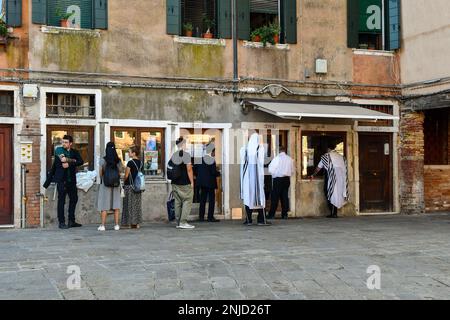 ebrei ortodossi e turisti fuori dalla Casa Chabad di Venezia a campo del Ghetto nuovo (Piazza del nuovo Ghetto) nel sestiere di Cannaregio, Venezia Foto Stock