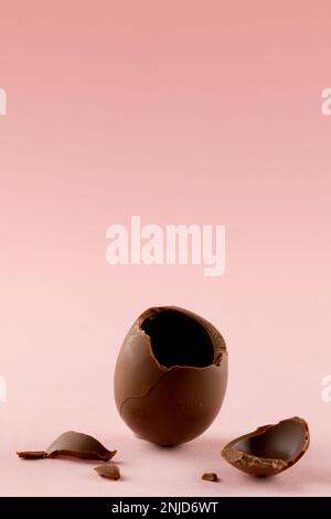 Immagine di cioccolato rotto uovo di pasqua e copia spazio su sfondo rosa Foto Stock