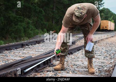 STATI UNITI Jason Walker, consulente ferroviario del 757th Expeditionary Railway Center (ERC), misura una rana nel corso di un'ispezione presso la base comune Langley-Eustis, Virginia, 6 agosto 2022. Le dimensioni e il tipo di rana determinano i limiti della velocità della rotaia e il peso che può sopportare. Foto Stock