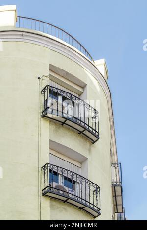 Facciata curva di un edificio residenziale con balconi in ferro battuto Foto Stock