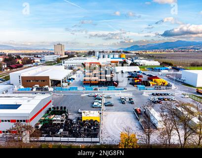 Un lotto di fabbrica con alcuni camion e magazzino all'aperto, fuco sparato Foto Stock