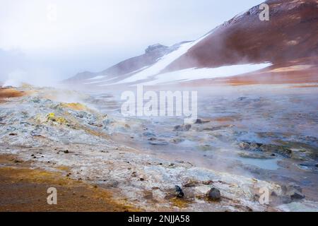 Melpentole bollenti nella zona geotermica Hverir e terra spaccata intorno. Posizione: Zona geotermica di Hverir, regione di Myvatn, parte nord dell'Islanda Foto Stock