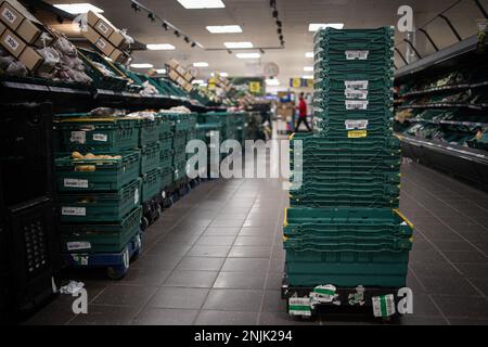 Londra, Regno Unito. 22nd Feb, 2023. Cestini vuoti di frutta e verdura fresca sono visti impilare nel mezzo della navata all'interno di un supermercato Tesco a Londra. I supermercati in tutta la Gran Bretagna stanno attualmente lottando per mantenere la fornitura di verdura fresca e frutta come pomodori, pepe e cetriolo a causa del clima sfavorevole in Europa meridionale. I supermercati concatenati, tra cui Aldi e Tesco, hanno annunciato restrizioni di razionamento e acquisto di alcuni tipi di frutta e verdura. Credit: SOPA Images Limited/Alamy Live News Foto Stock