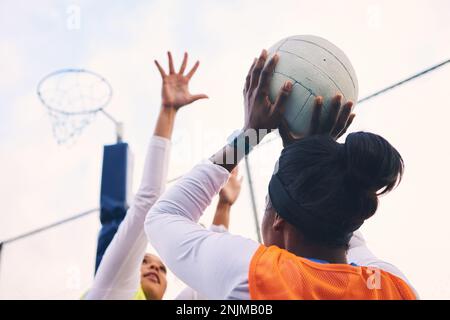Netball, gol shooter e fitness di un gruppo di atlete su un campo sportivo all'aperto. Mira, gioco sportivo e sfida partita di una persona nera con un Foto Stock