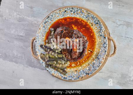 Agnello confit con piselli di neve in salsa sul piatto. Giacitura piatta. Foto Stock