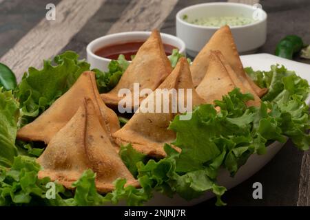 Spuntini di patate Samosa su sfondo testurizzato. Cibo indiano Ramadan, pasto pakistano Iftar. Foto Stock