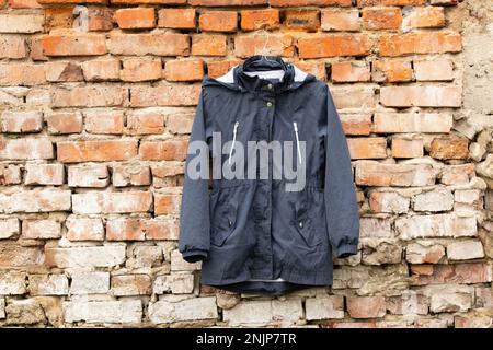 Appendiabiti con vestiti sul muro di mattoni Foto stock - Alamy