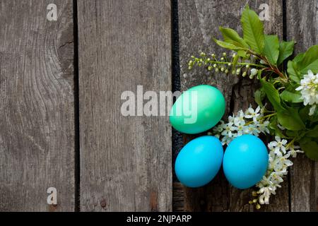 Cena di Pasqua, uova di pollo colorate su un vecchio tavolo di legno la sera Foto Stock