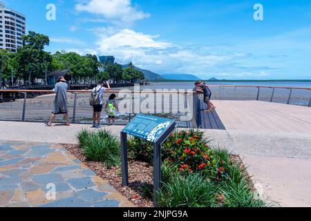 I turisti che si trovano sul lungomare lungo Cairns Esplanade in una giornata di sole, Cairns, far North Queensland, FNQ, QLD, Australia Foto Stock