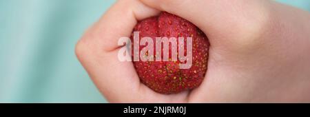 Fragole clenched in pugno sotto forma di costipazione del colon Foto Stock