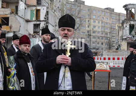 Non esclusiva: DNIPRO, UCRAINA - 22 FEBBRAIO 2023 - Un sacerdote tiene un crocifisso durante il servizio commemorativo organizzato 40 giorni dopo il bui residenziale Foto Stock