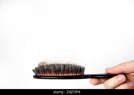 Problema di perdita dei capelli, periodo postpartum, disturbi mestruali o endocrini, squilibrio ormonale, concetto di stress. Molti capelli cadono dopo la pettinatura con la spazzola per capelli Foto Stock