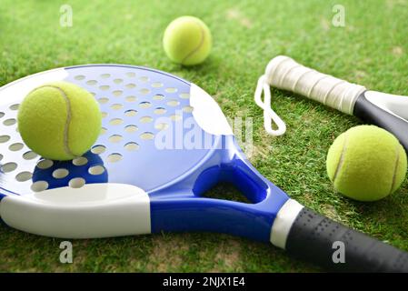 Racchette e palle in palle su erba artificiale nel campo all'aperto. Vista rialzata. Foto Stock