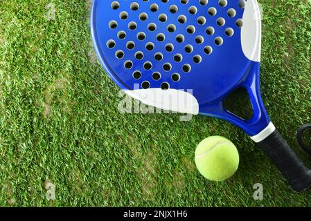 Sfondo di racchetta di padel e palla su erba artificiale nel campo all'aperto. Vista dall'alto. Foto Stock