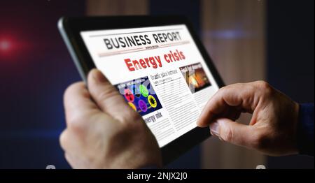 Crisi energetica e gas combustibile prezzo dell'elettricità quotidiano lettura su schermo mobile tablet computer. Uomo touch screen con titoli notizie abstract c Foto Stock