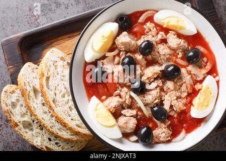 Insalata tradizionale di moje murciana fresca e deliziosa con pomodori in scatola, tonno, uova e cipolle condite con olio vergine di oliva closeup sul piatto. Hori Foto Stock