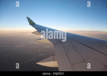 Questa splendida foto di scorta cattura la vista mozzafiato dalla finestra di un aereo passeggeri, che mostra l'impressionante ala dell'aereo che sorvola il thro Foto Stock