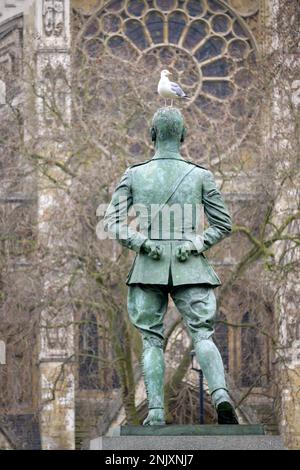 Londra, Inghilterra, Regno Unito. Seagull sulla testa della statua di Jan Smuts in Parliament Square, Abbazia di Westminster dietro. Foto Stock