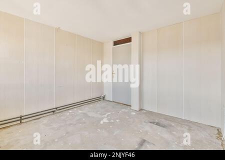 Design interno di camere spaziose e luminose con nuovi sfondi beige su vecchie pareti e pavimento in cemento Foto Stock