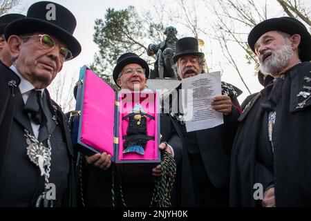 Un membro della Confraternita Sardina tiene la bara con la Sardina e a sua destra un altro membro grida al pubblico la proclamazione dell'anno, prima di iniziare la celebrazione della sepoltura del carnevale della Sardina che ha girato le strade di Madrid. La sepoltura della sardina è una processione funebre che si celebra ogni Mercoledì delle Ceneri, per dire Arrivederci alla settimana di carnevale a Madrid, si ritiene che la festa risale al 18th ° secolo. Si festeggia il passaggio ai quaranta giorni precedenti l'arrivo della settimana Santa. Foto Stock