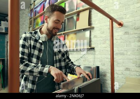 Giovane uomo che sceglie dischi in vinile in negozio Foto Stock