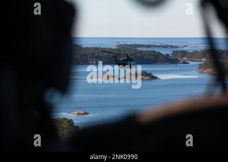 Un elicottero Blackhawk dell'esercito degli Stati Uniti UH-60 assegnato a 12th Brigata dell'aviazione di combattimento, vola a fianco di elicotteri finlandesi NH-90 durante un addestramento congiunto di sequestro dell'isola a Russaro Island, Finlandia, 10 agosto 2022. L'addestramento è stato parte di un esercizio bilaterale tra le forze militari finlandesi e statunitensi con l'unità di spedizione marina (MEU) 22nd e l'esercito degli Stati Uniti. Il Kearsarge Amphibious Ready Group e 22nd MEU, sotto il comando e il controllo della Task Force 61/2, è in programma un dispiegamento nell'area operativa delle forze Navali USA in Europa, impiegata dalla U.S. Sesta flotta per difendere gli Stati Uniti, alleati e p Foto Stock