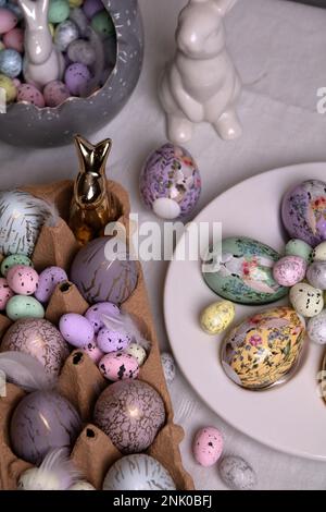 foto dipinta in diversi colori uova e coniglio in ceramica sul tavolo Foto Stock