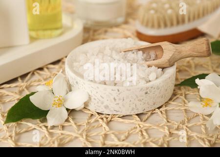 Sale marino in ciotola e bellissimi fiori di gelsomino su tavola bianca Foto Stock