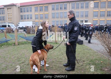 Erfurt, Germania. 23rd Feb, 2023. Schoolgirl Abbey Rudolph (15) apprende circa il lavoro della polizia dal capitano di polizia Marco Kupfer con il cane di servizio Lotte all'apertura della campagna di reclutamento della polizia Turingia nel cortile della Kommunale Gesamtschule am Schwemmbach. Credit: Bodo Schackow/dpa/Alamy Live News Foto Stock