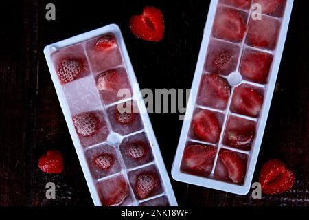 Ghiaccio di fragola nelle forme. Preparazione del ghiaccio estivo per cocktail, gelato e dessert. Spazio di copia. Foto Stock