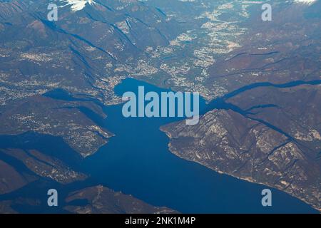 Vista sul lago d'Iseo e sulle Alpi dalla finestra dell'aereo . Vista panoramica sulle montagne con il lago in Italia Foto Stock