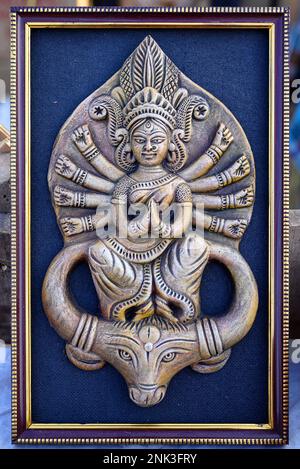 Bella scultura fatta a mano di Dea Devi Durga è esposta in un negozio in vendita su sfondo sfocato. Arte indiana e artigianato. Foto Stock