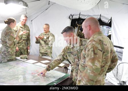 Richard Ferguson, comandante della Brigata dell'aviazione di combattimento del 29th, a sinistra, e il Lt. David Magness, funzionario ESECUTIVO del CAB del 29th, entrambi con la Guardia nazionale dell'esercito del Maryland discutono gli obiettivi per una missione di assalto aereo imminente come parte del Northern Strike 22 a Grayling, Michigan, il 11 agosto 2022. Northern Strike ’22 porta circa 7.400 partecipanti da 19 stati e 4 paesi di coalizione nel Michigan settentrionale per convalidare la disponibilità e l'interoperabilità dei partner multicomponente, multinazionale e interagenzia dal 6 al 20 agosto 2022, presso il National All Domain Warfighting Center. Foto Stock