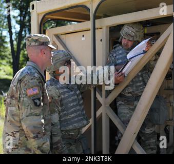 STATI UNITI Army Reserve Sgt. 1st Classe Anthony Taylor (a sinistra), Abdiel Colon (centro), 810th Quartermaster Company, esamina un foglio di calcolo di galloni all'ora (GPH) per verificare la produttività del Tactical Water Purification System (TWPS) durante l'esercitazione di addestramento di supporto di combattimento (CSTX) 86-22-02 ospitata dalla 86th Training Division (TD) su Fort McCoy, Wisconsin, 11 agosto 2022. CSTX è un'esercitazione sviluppata per addestrare le unità della riserva dell'esercito e i soldati per schierarsi con breve preavviso e portare le capacità capaci, pronte per il combattimento e letali a sostegno dell'esercito e dei nostri soci Uniti dovunque nel worl Foto Stock