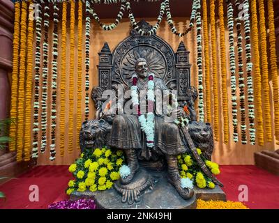 Nuova Delhi, India - novembre 2022: Grande re guerriero indù Chatrapati Shivaji Maharaj maratha. Idolo in legno Shivaji con sfondo a catena di fiori appeso. Foto Stock