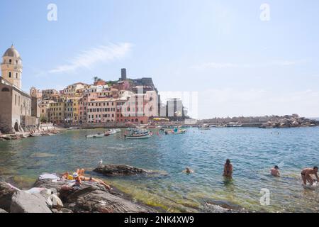 Vista sul porto di Vernazza, cinque Terre, Liguria con gente che si gode il mare Foto Stock