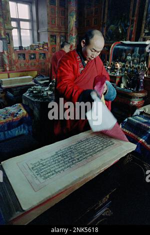 Ulaanbaatar, Mongolia. 26 gennaio 1990. Il lama buddista Baasan Dorligjav copre un Tripitaka all'interno del monastero di Gandan Tegchinlen, conosciuto anche come monastero di Gandan, gennaio 26,1990 a Ulaanbaatar, Mongolia. Baasan è anche un leader nella Foto Stock