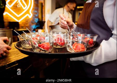 preparazione del gelato con porzioni di gelato all'azoto liquido in ciotole su un piatto al cameriere Foto Stock