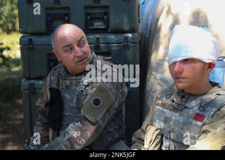 STATI UNITI Army Chief Warrant Officer 4 Troyray Gillespie, a sinistra, un Brigade Maintenance Officer assegnato a Charlie Company, 237th Battaglione di supporto e Stati Uniti Alexander Maiden, a destra, un operatore-manutentore di sistemi di trasmissione multicanale assegnato a Charlie Company, 237th Battaglione di supporto, attendono l'evacuazione medica durante un evento di addestramento simulato come parte dell'operazione Northern Strike a Camp Grayling, Michigan, 11 agosto 2022. L'evento è stato condotto per simulare possibili eventi di triage reali che i soldati potrebbero incontrare quando dispiegati o attivati al fine di prepararli meglio a trattare Foto Stock