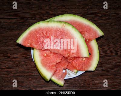 fettine di cocomero su sfondo di legno Foto Stock