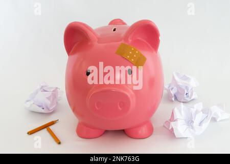 Simbolo di una banca piggy per l'inflazione, l'economia e la crisi. Rosa su sfondo bianco Foto Stock